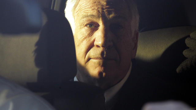 Former Penn State assistant football coach Jerry Sandusky sits in the back seat of his attorney's car as he leaves the Centre County Courthouse in Bellefonte, Pa., Dec. 13, 2011. 