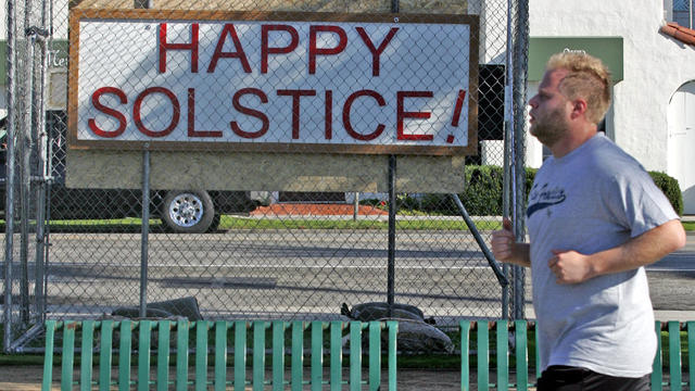 A man runs past a sign displaying a "Happy Solstice" message along Ocean Avenue at Palisades Park in Santa Monica, Calif., Dec. 13, 2011. Most of the Christmas nativity scenes that local churches had placed in a Southern California coastal park for nearly 