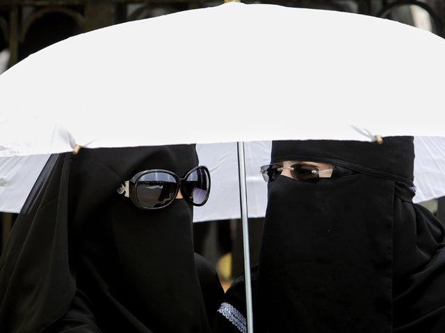 Female anti-government protestors shelter from the sun 
