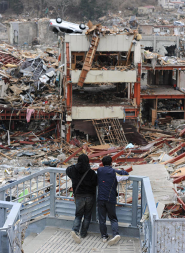 Two boys look at a devastated area in Onagawa 