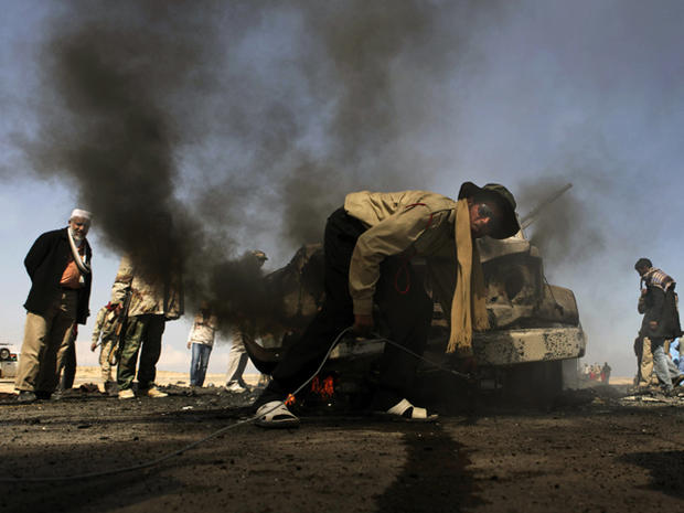 Libyan rebels prepare to tow a vehicle 