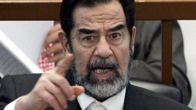 Former Iraqi President Saddam Hussein points while listening to the prosecution during his genocide trial Dec. 21, 2006, in Baghdad. 
