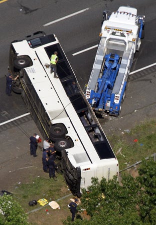 Rescue personnel work on a bus that overturned  