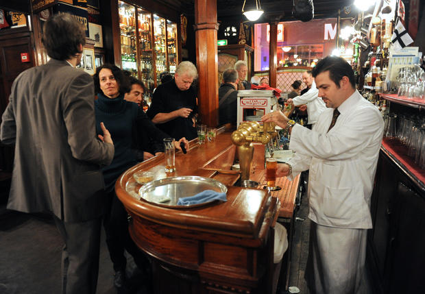 A waiter prepares a beer for a client on 