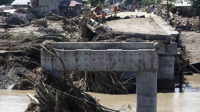 Workers clean up debris from the destroyed Old Hinaplanon Bridge 