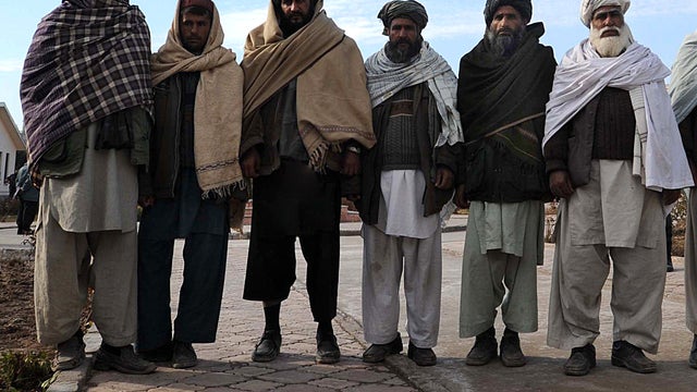 Former Taliban fighters stand after they joined Afghan government forces during a ceremony in Herat, Afghanistan, Jan. 5, 2012. 