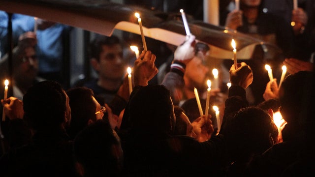 Syrians hold a candlelight vigil as the body of French television reporter Gilles Jacquier is taken out of a hospital in Homs, Syria, to be transported to the capital city of Damascus early Jan. 12, 2012. Paris demanded an investigation after Jacquier was 