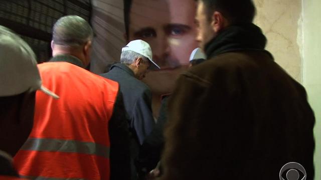 Observers from the Arab League arrive at the Damascus Criminal Justice Headquarters, where the image of Syrian president Bashar al-Assad is prominent on the walls.  