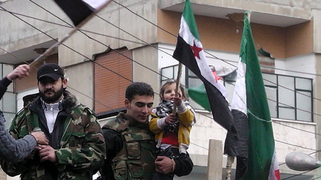 Members of the Free Syrian Army gather in the Khalidiya neighborhood of the flashpoint city of Homs, Syria, Jan. 13, 2012, as thousands protested in support of the rebels throughout the country. 