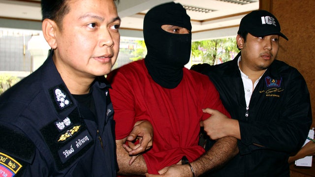 A Lebanese suspect with alleged links to Hezbollah militants is escorted for interrogation at the Thai border police headquarters in Bangkok, Thailand, Jan. 16, 2012. A Thai television station is reporting that the suspect has led police to a warehouse ho 