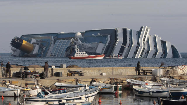 People view the cruise ship Costa Concordia from the harbor wall 