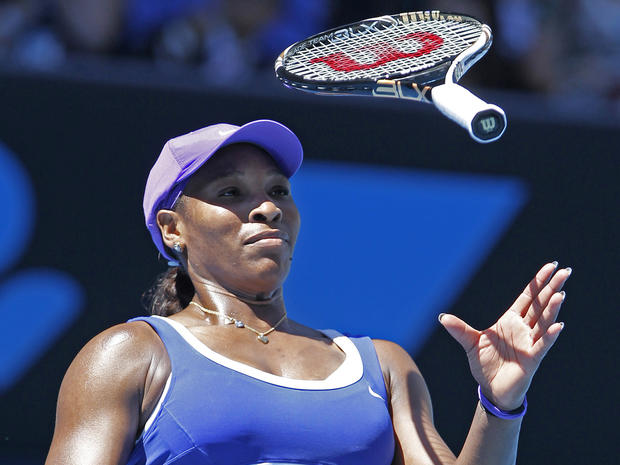 Serena Williams bounces her racket  