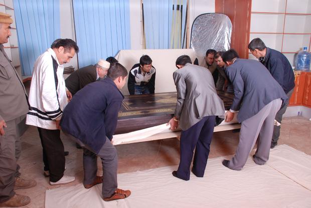 Workers heft the 1,102 pound Quran in Kabul 