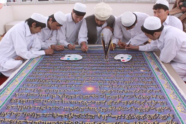 Afghan calligrapher Mohammed Sabeer Hussani, center, and nine student apprentices work on a page for the world's largest Quran 
