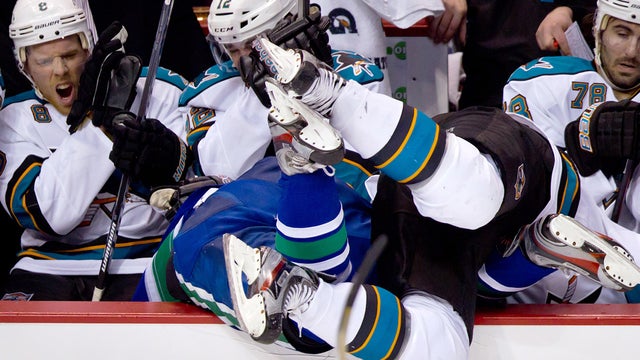 Jamie McGinn checks Dan Hamhuis into the San Jose bench  