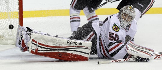 Corey Crawford watches as a shot gets past him for a goal 