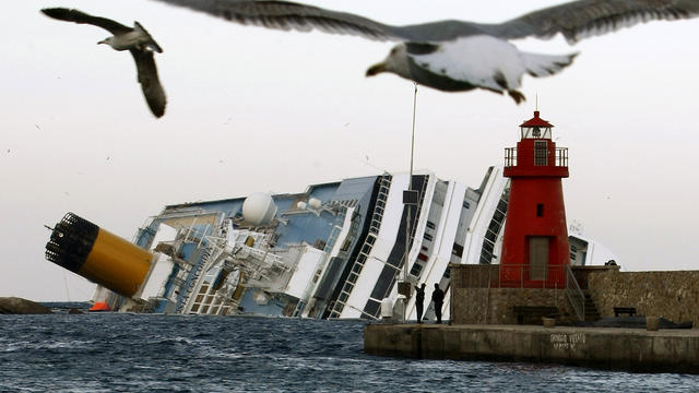 Seagulls fly in front of the grounded cruise ship Costa Concordia off the Tuscan island of Giglio, Italy, Jan. 30, 2012. Residents of Giglio are growing increasingly worried about threats to the environment and the future of the island as bad weather agai 