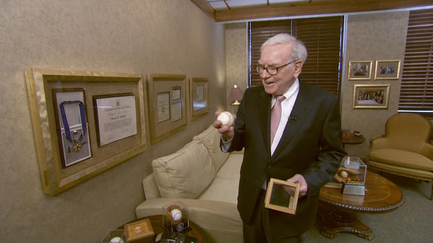 Buffett shows off a baseball signed by one of his heros, Stan Musial fo the St. Louis Cardinals 