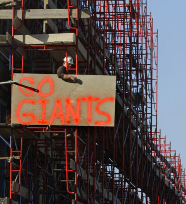Construction worker Frank Kazanecki tie a giant painted sign to the Pier A construction 