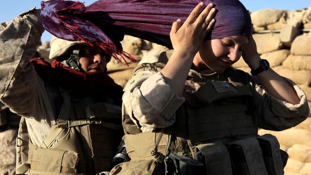 U.S. Marine Sgt. Monica Perez, of San Diego, left, helps Lance Cpl. Mary Shloss of Hammond, Ind., put on her head scarf before heading out on a patrol in the village of Khwaja Jamal, Afghanistan, Aug. 10, 2009. 