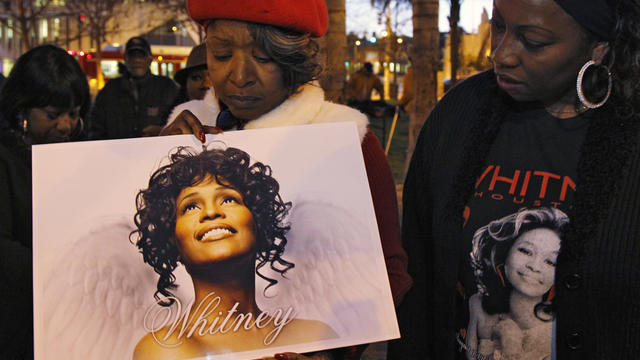 Whitney Houston fans, Lawanda Howkins, left, and Melanie Braggs honor her memory at a candlelight vigil  