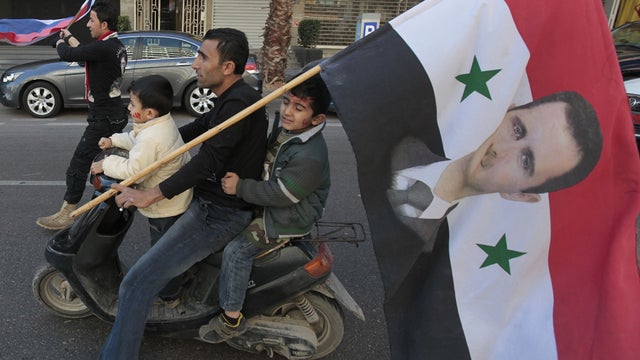 Pro-Syrian regime protester rides his scooter with his two sons in Beirut, Lebanon 