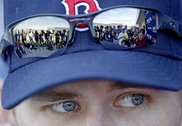 Members of the media are reflected in the sunglasses of Boston Red Sox pitcher Daniel Bard 
