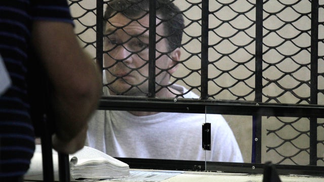Reality television producer Bruce Beresford-Redman attends a court hearing from behind a fenced window at the prison in Cancun, Mexico 