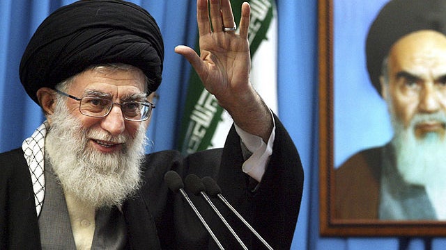 In this Friday, Feb. 3, 2012 file photo released by an official website of the Iranian supreme leader's office, Iranian supreme leader Ayatollah Ali Khamenei waves to the worshippers, in front of a portrait of the late revolutionary founder Ayatollah Khom 