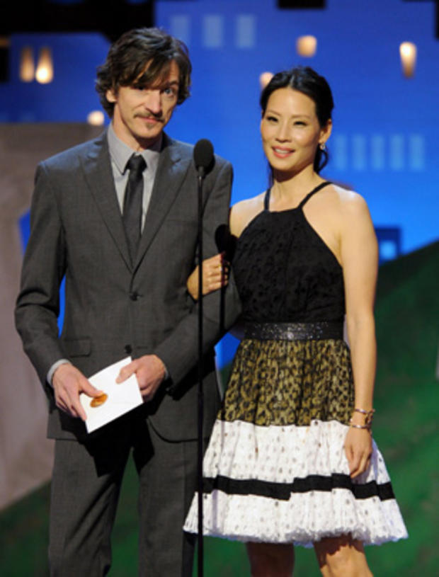 John Hawkes, left, and Lucy Liu speak onstage at the Independent Spirit Awards  