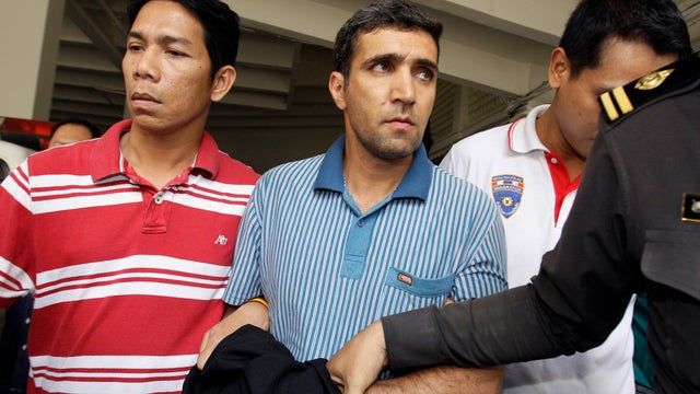 Iranian bomb suspect Mohammad Kharzei, right, listens to a Thai police officer Feb. 20, 2012, as he is taken to verify the house that he and other Iranian compatriots rented in Bangkok. 