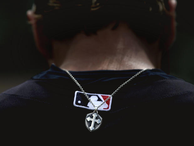 A cross hangs from a necklace of Chris Herrmann 