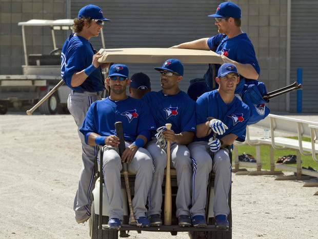Toronto Blue Jays Colby Rasmus, top left, Adam Lind, top right, Jose Bautista, front left, Eric Thames, center, and Jeff Mathis, front right, load up a golf cart to catch a ride back to the clubhouse 