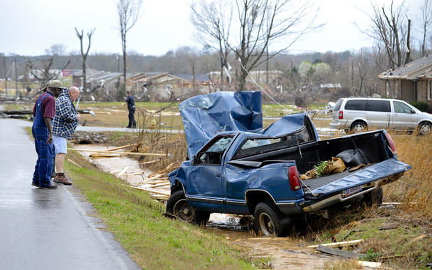 People look at a truck that was blown off the road by debris from a reported tornado 