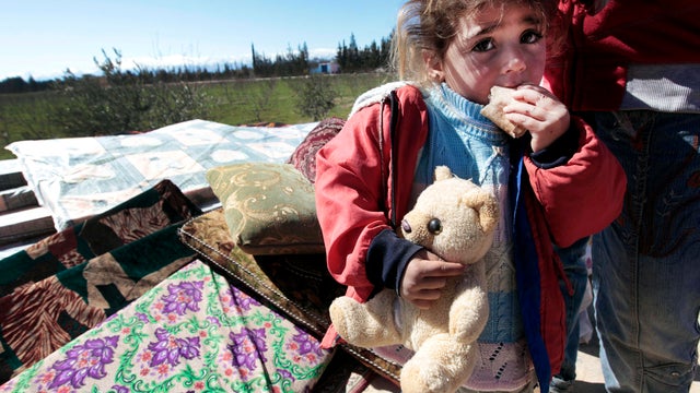 A Syrian child is seen with her family who fled from the Syrian town of Qusair, near Homs, at the Lebanese-Syrian border village of Qaa, Lebanon, March 5, 2012. 