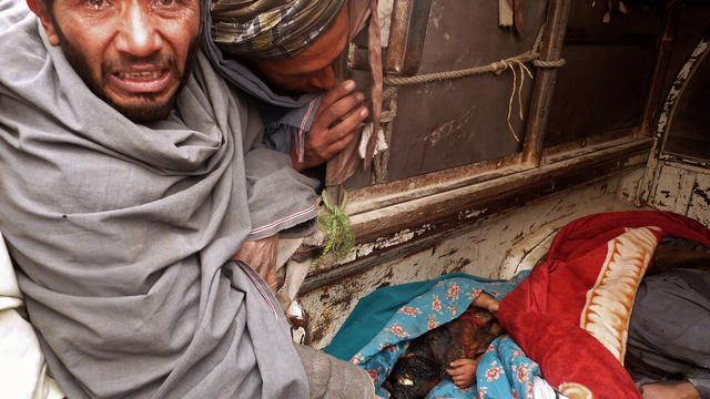 A mourner cries over the bodies of Afghan civilians 