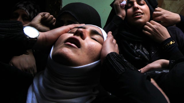 Palestinian relatives of Islamic Jihad militant Mohammed Daher, who was killed the night before along with another comrade in an Israeli air strike, mourn during his funeral in Gaza City March 13, 2012. 