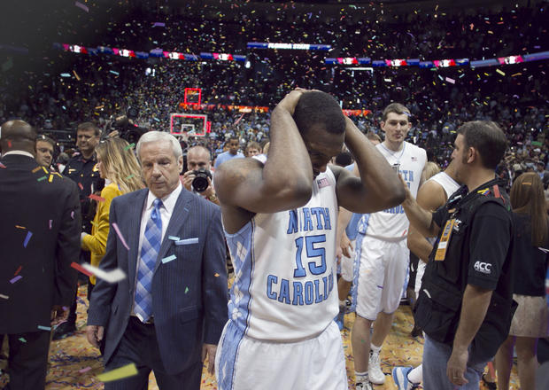 North Carolina's P.J. Hairston (15) and coach Roy Williams leave the court amid a shower of confetti 