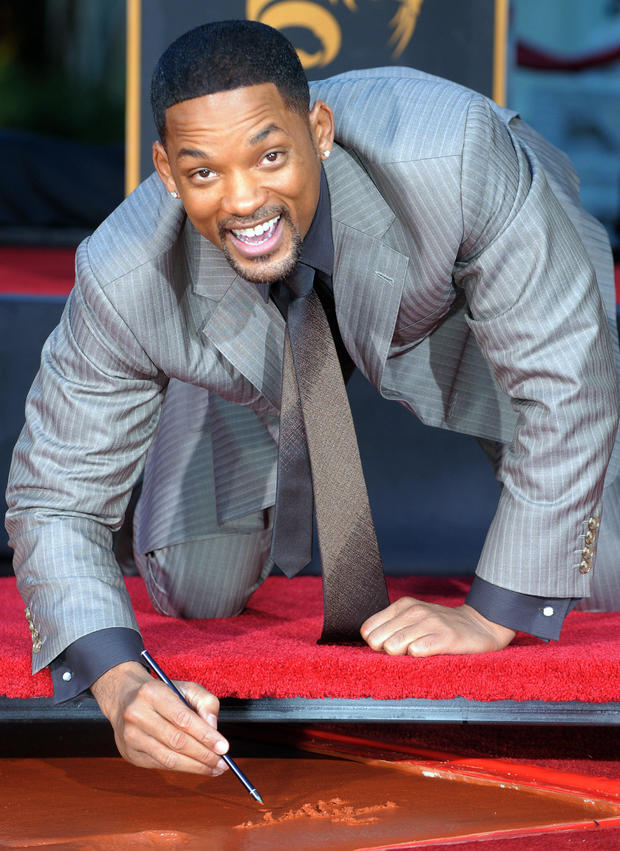 gabriel-bouys-us-movie-star-will-smith-signs-his-name-in-cement-during-a-hand-and-footprint-ceremony.jpg 