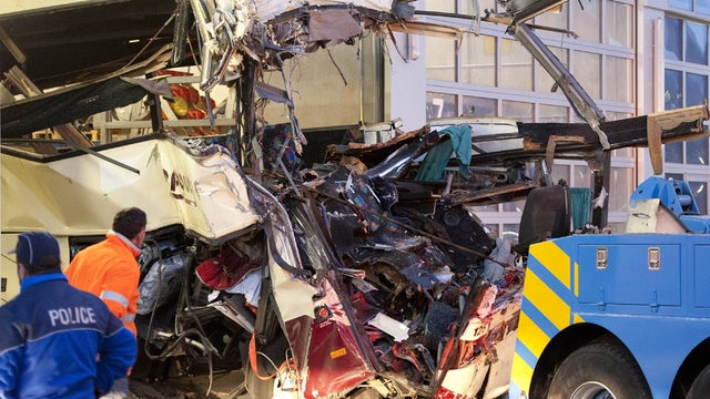 Wreckage of a tourist bus from Belgium is dragged by a tow truck outside a motorway tunnel 