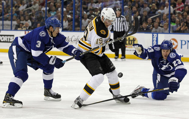 Boston Bruins' Tyler Seguin, center, is checked by Tampa Bay Lightning's Keith Aulie 