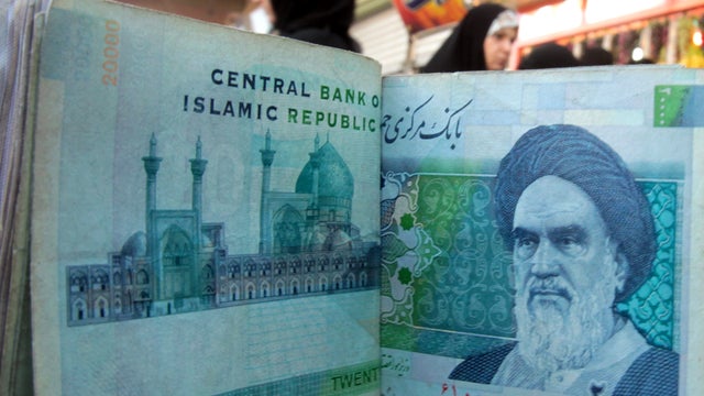 An Iraqi money dealer counts Iranian rial banknotes bearing a portrait of the late founder of the Islamic Republic of Iran, Ayatollah Ruhollah Khomeini, at an exchange office in Baghdad Feb. 3, 2012. 