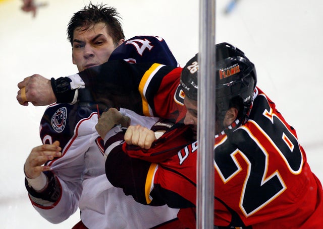 Columbus Blue Jackets' Jared Boll, left, fights with Calgary Flames' Guillaume Desbiens  