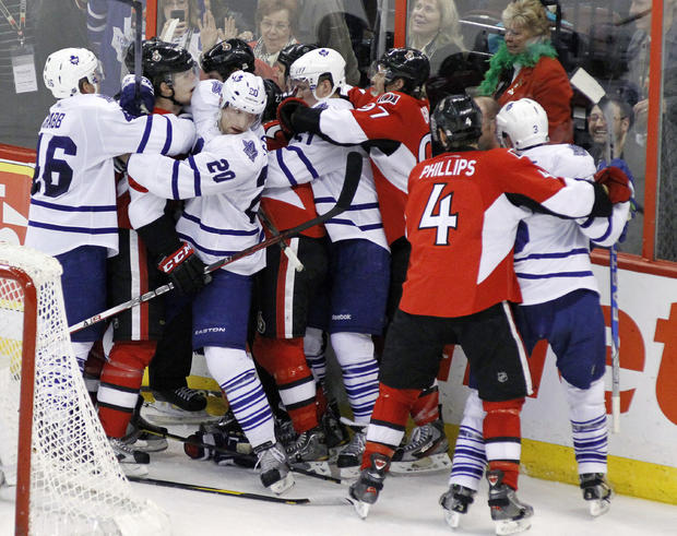 Players from the Ottawa Senators and Toronto Maple Leafs fight 