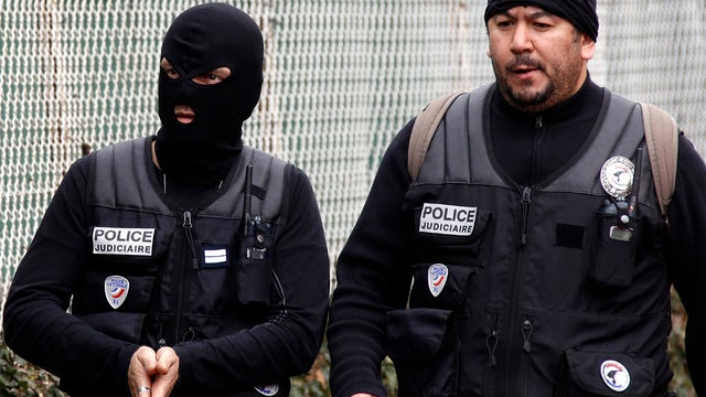 Police officers stand near a building in Toulouse, France, March 21, 2012, where a suspect in the shooting at the Ozar Hatorah Jewish school is barricaded in an apartment building. 