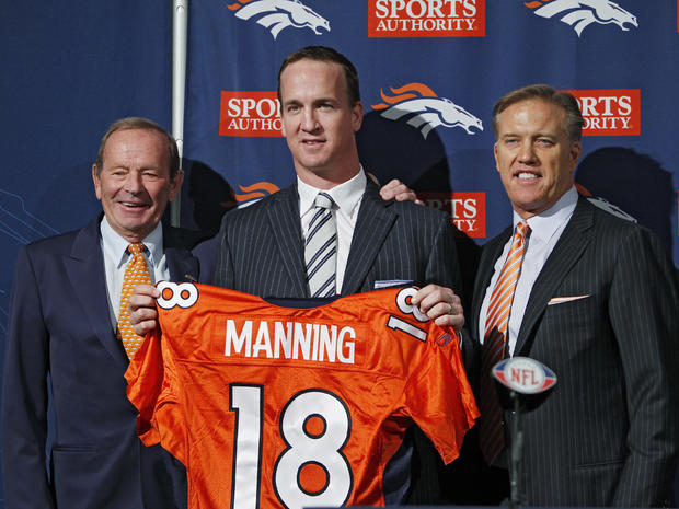 Peyton Manning, center, is flanked by Broncos owner Pat Bowlin, left, and vice president John Elway 