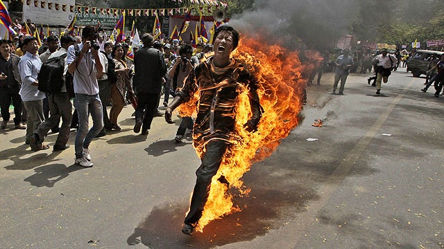A Tibetan exile man, identified as Jampa Yeshi, runs engulfed in flames after self-immolating during a demonstration in New Delhi, India, March 26, 2012.  
