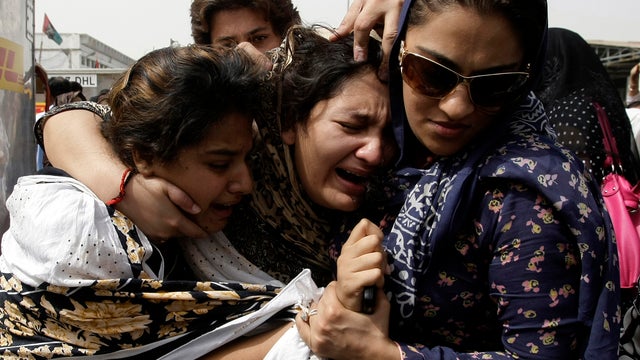 Family members of Pakistani acid attack victim Fakhra Younnus mourn her death at Karachi airport in Pakistan March 25, 2012. 