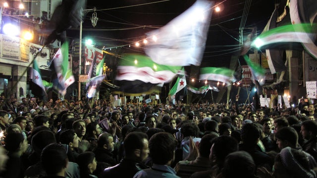 Syrians wave revolutionary flags and chant slogans at a night protest against President Bashar Assad in a neighborhood of Damascus, Syria, April 2, 2012.  