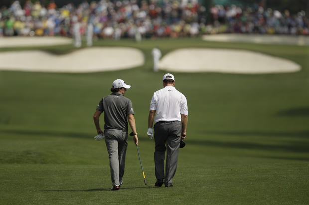 Rory McIlroy walks down the seventh fairway with Tom Watson 